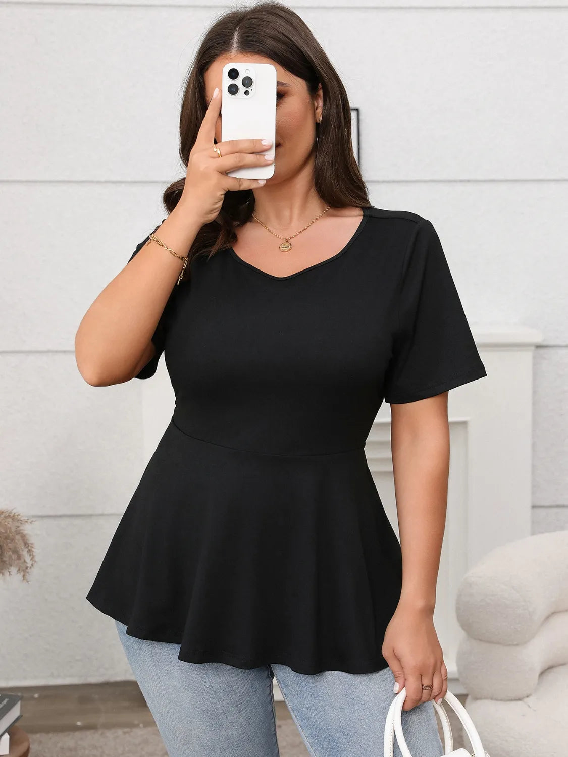 Stylish Bow Back Short Sleeve Blouse in black, featuring a flattering peplum design and soft polyester-elastane fabric.