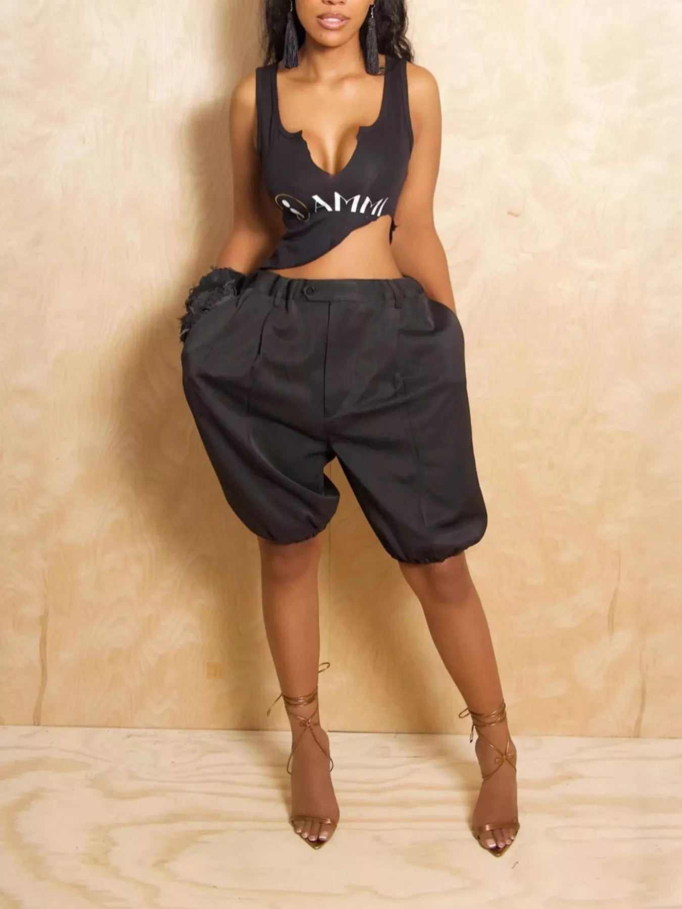 Model wearing black Pleated Detail High Waist Shorts with drawstring and pockets, knee-length.