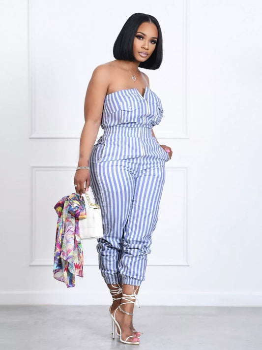 Striped blue-and-white tube jumpsuit with pockets and cinched waist, 95% polyester 5% spandex, model in white heels.