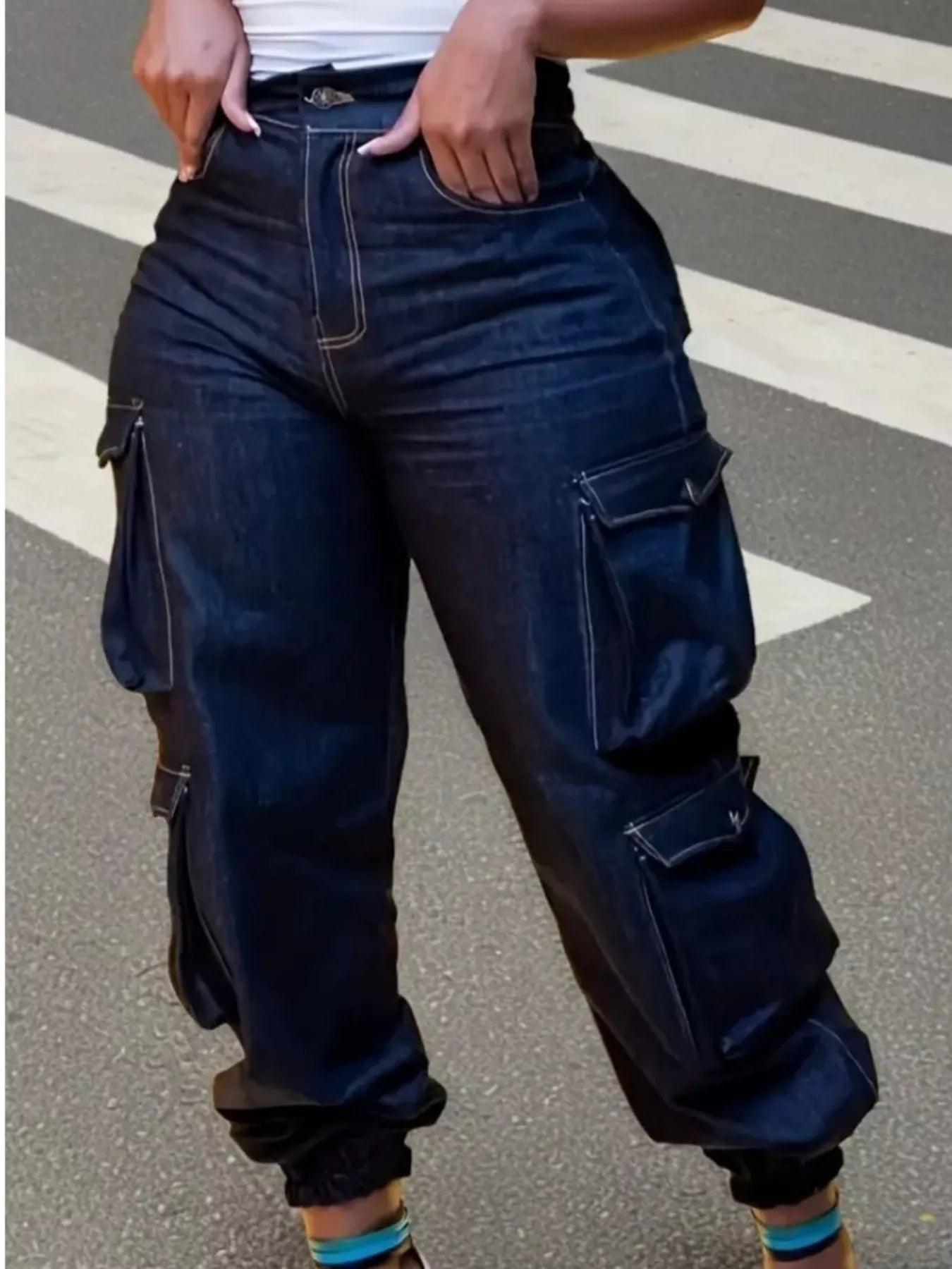 Dark wash curvy cargo denim jeans featuring a flattering silhouette, large side pockets, and elastic cuffed ankles for comfortable everyday wear.