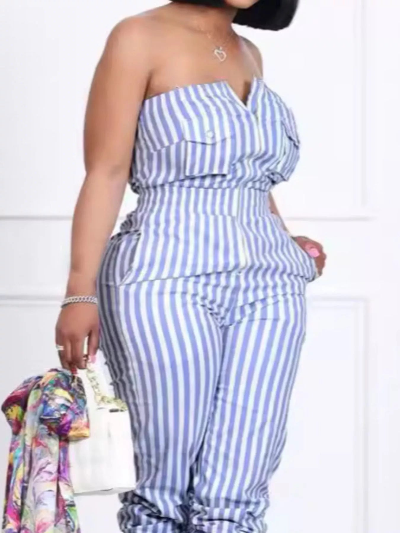 Woman wearing blue-and-white striped tube jumpsuit with pockets and elastic waist.