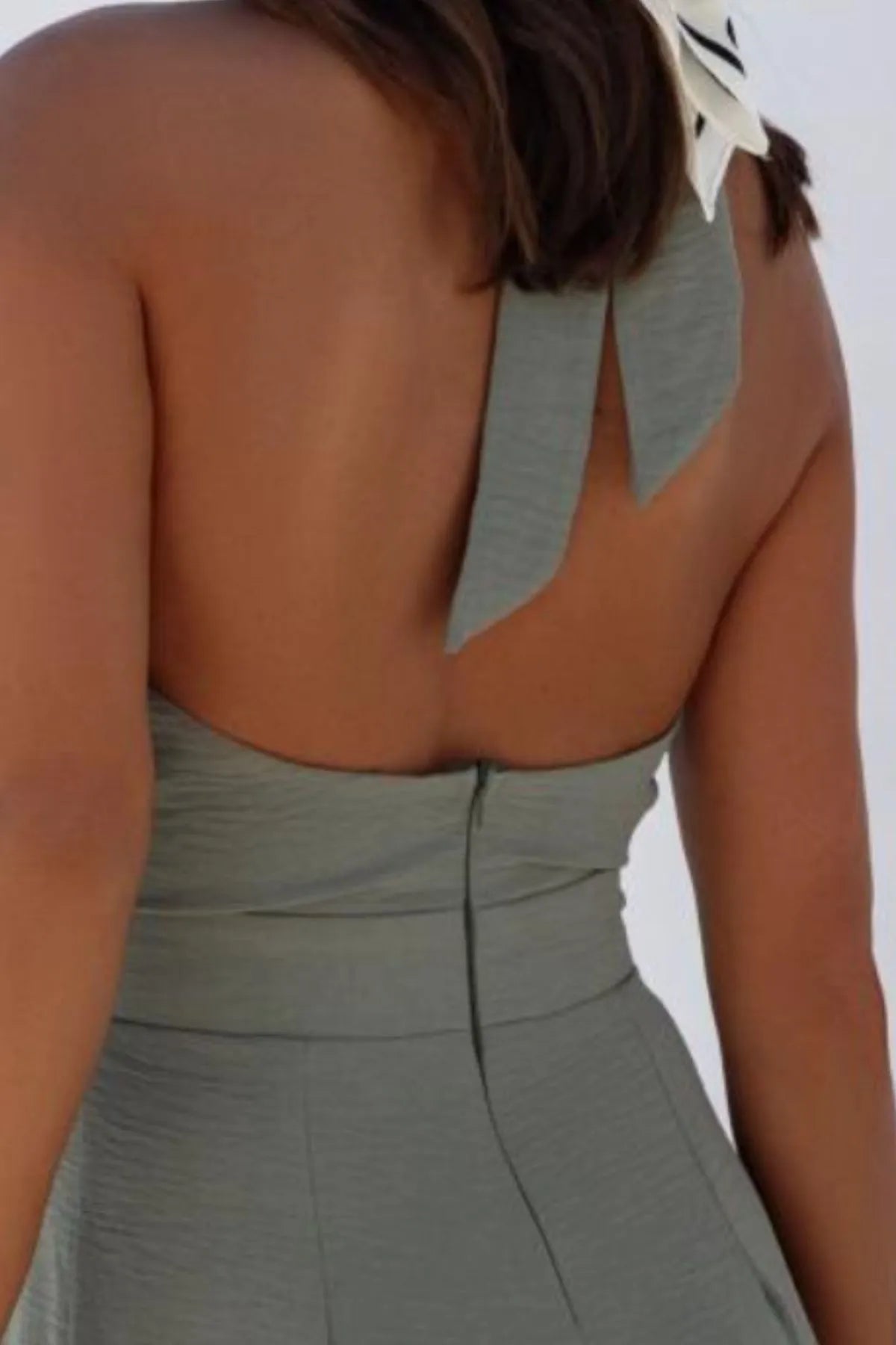 Halter Neck Wide Leg Jumpsuit with Keyhole Detail featuring cutout backless design and crisscross style, perfect for stylish occasions.